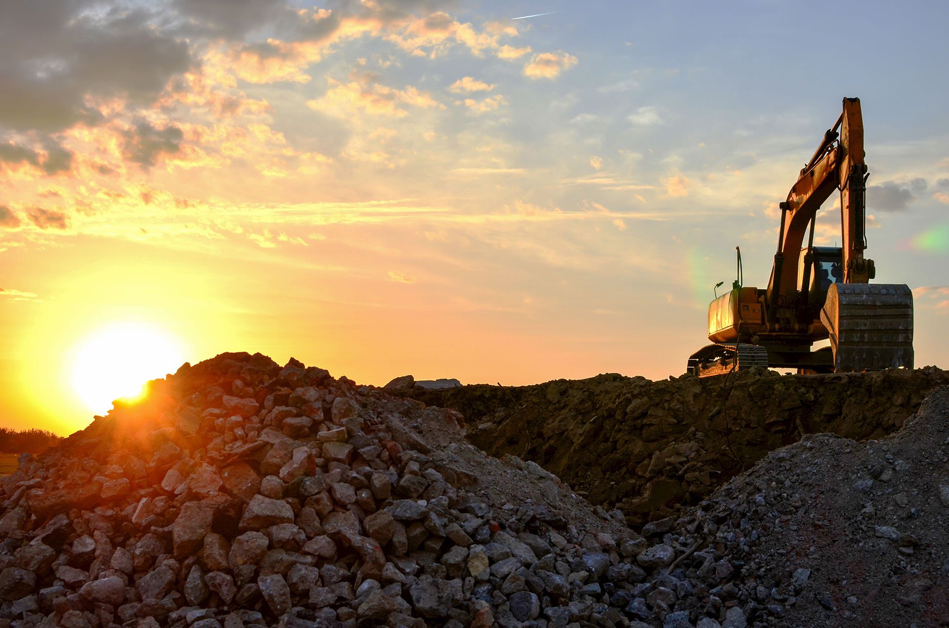 An image of a digger on top of an excavated pit